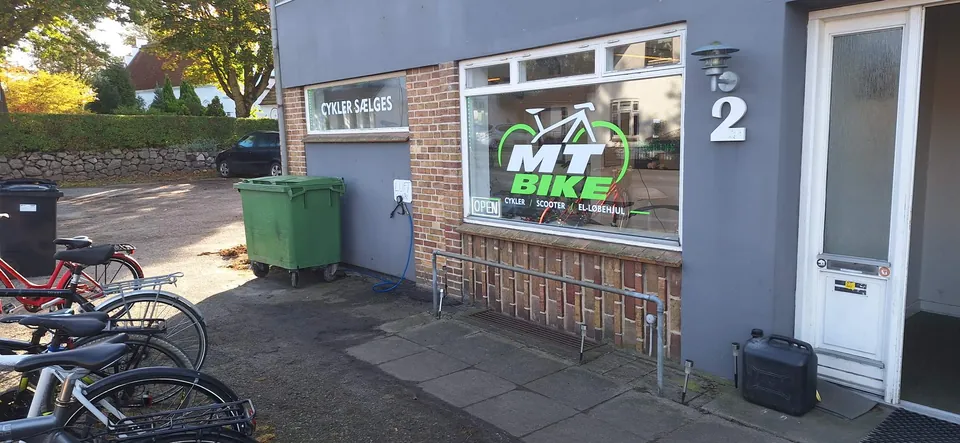 Facaden på MT Bike med logo i vinduet og luftslange på muren
